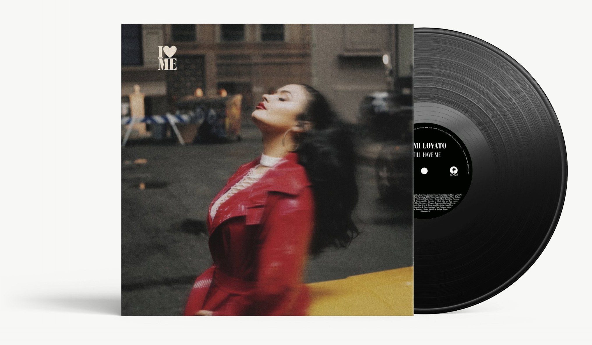 Demi Lovato, I Love Me on vinyl: a blurred photograph of the singer in a red coat on a city street, I-heart-ME set small in the corner, the record sliding out